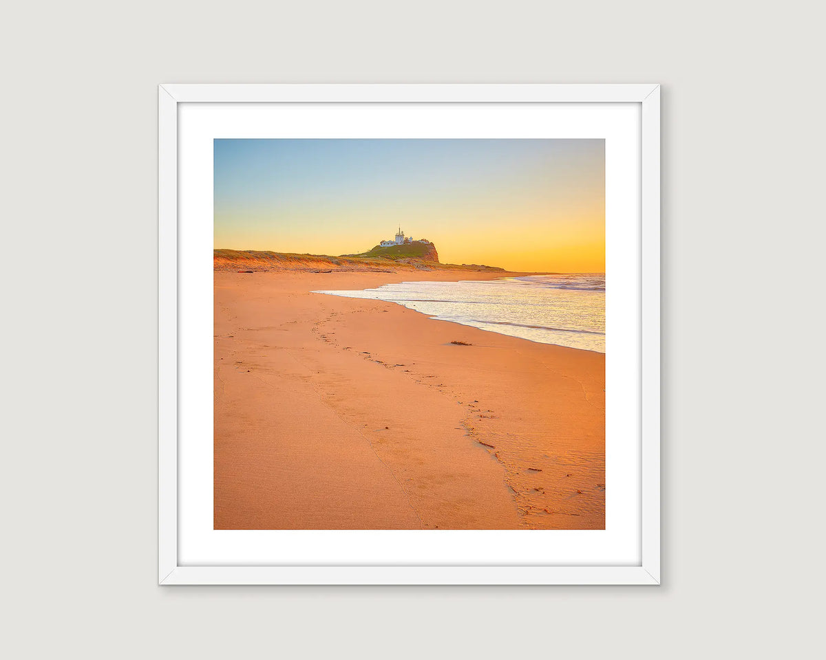 Framed photograph of an ocean with a golden sunrise.