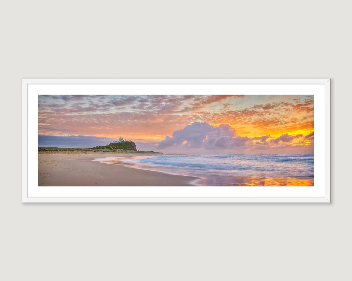 Framed landscape photograph of a beach with a cloudy golden sunrise.