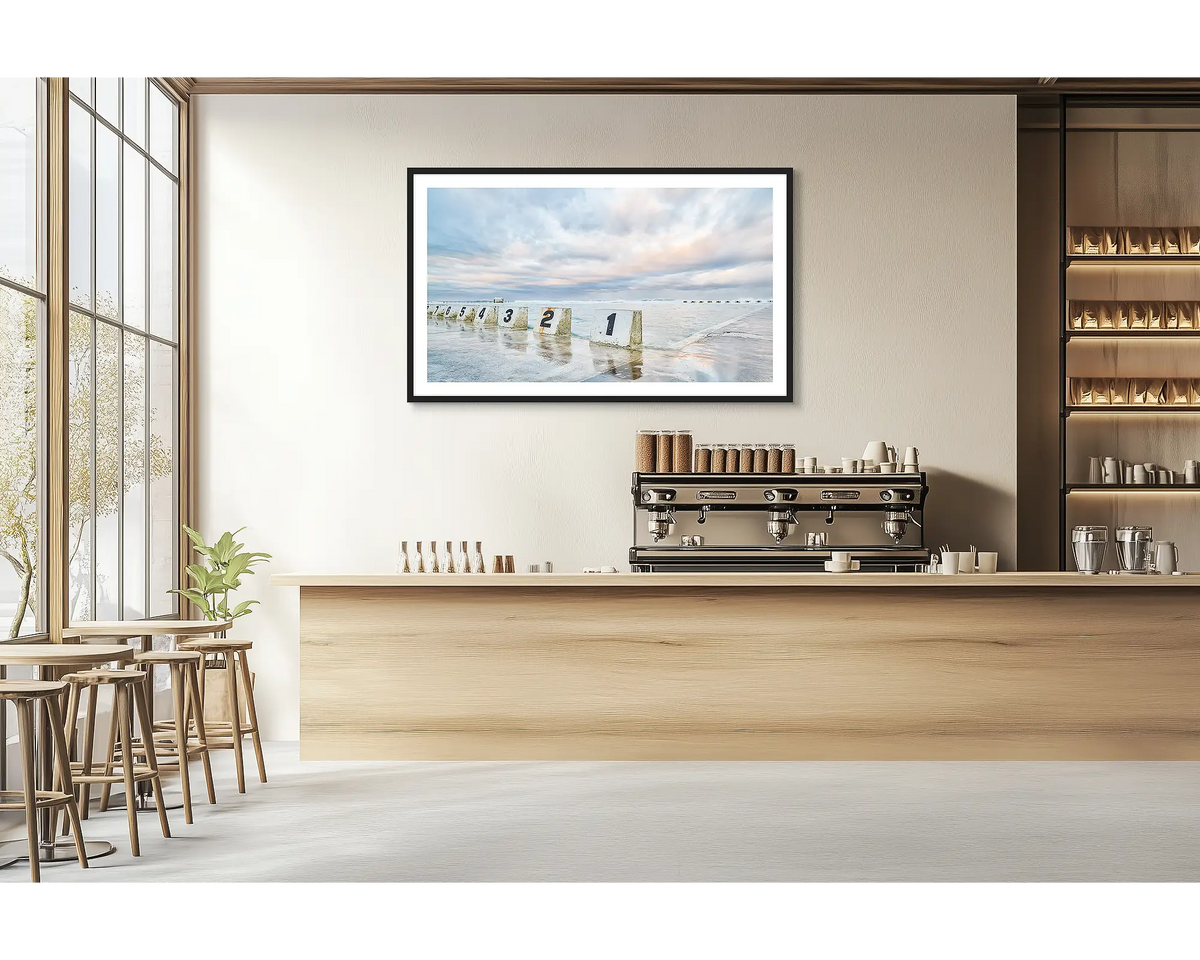 Ocean Baths. Merewether ocean baths wall art print with a black frame hung in a cafe. 

