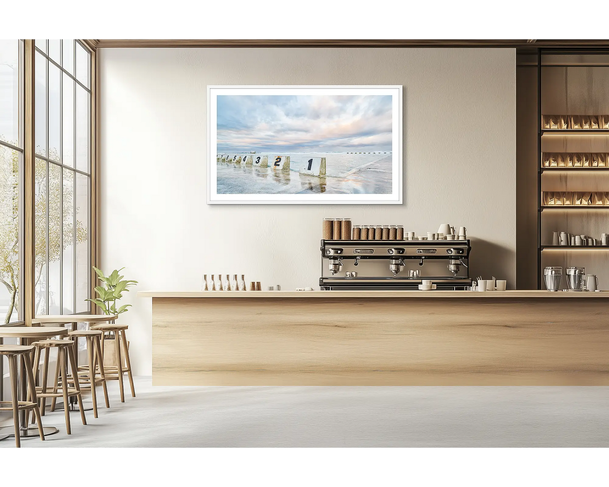 Ocean Baths. Merewether ocean baths wall art print with a white frame hung in a cafe. 
