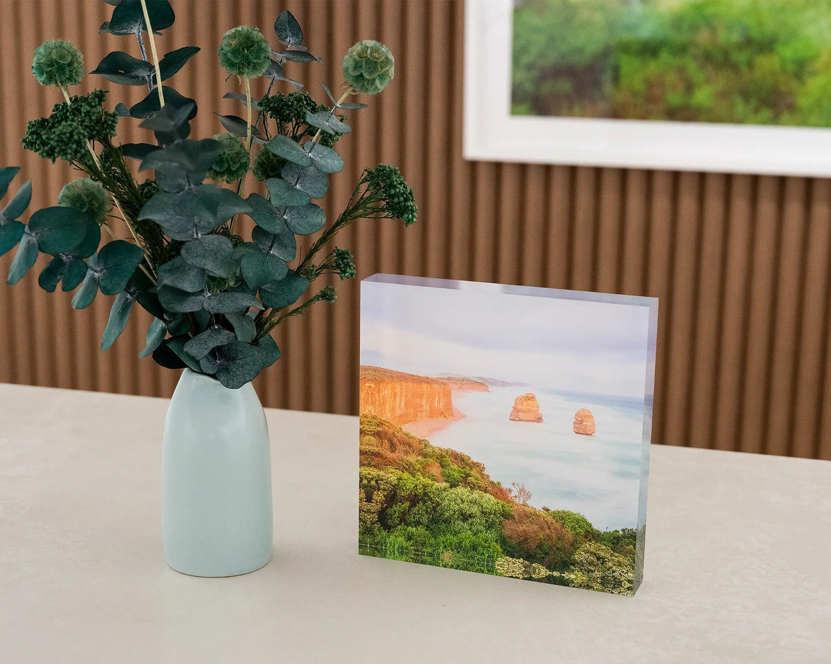 Ocean Blur. Acrylic block Great Ocean Road, Victoria, on desk styled with flower vase and artwork in background.
