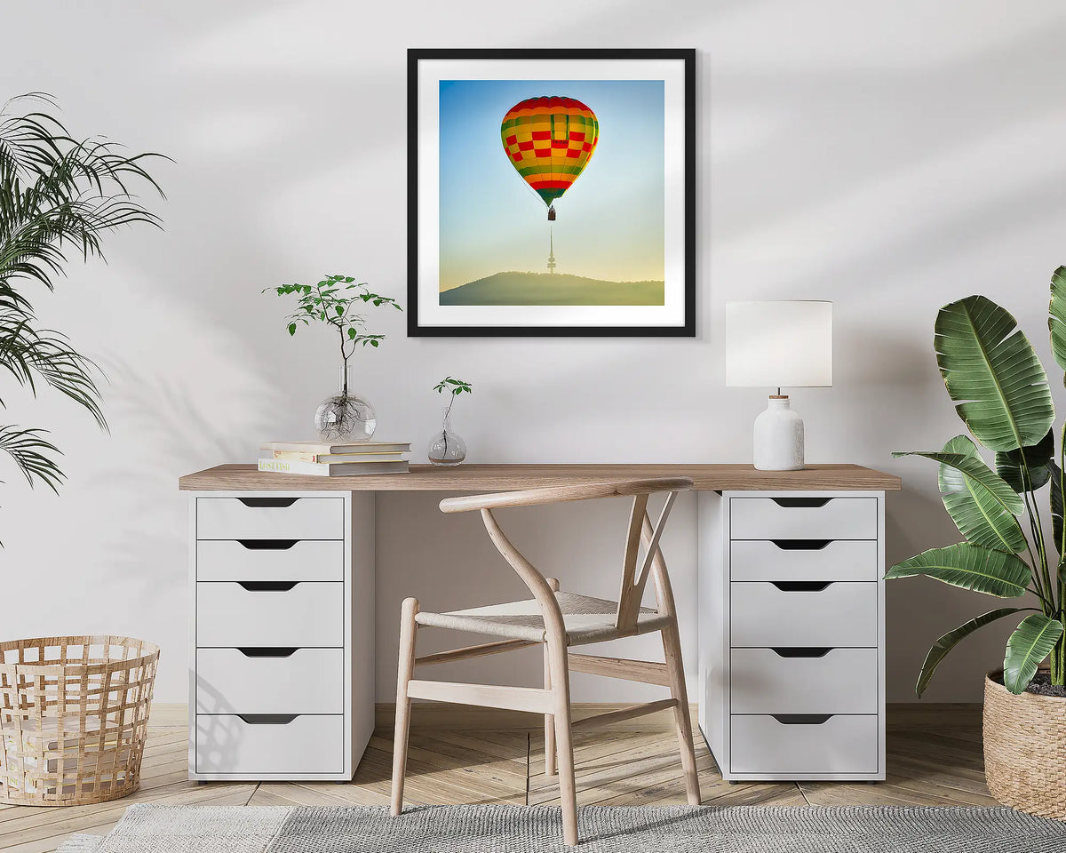 On Top. Canberra wall art print of a hot air balloon and Black Mountain Tower, framed in a black and hung in a study. 