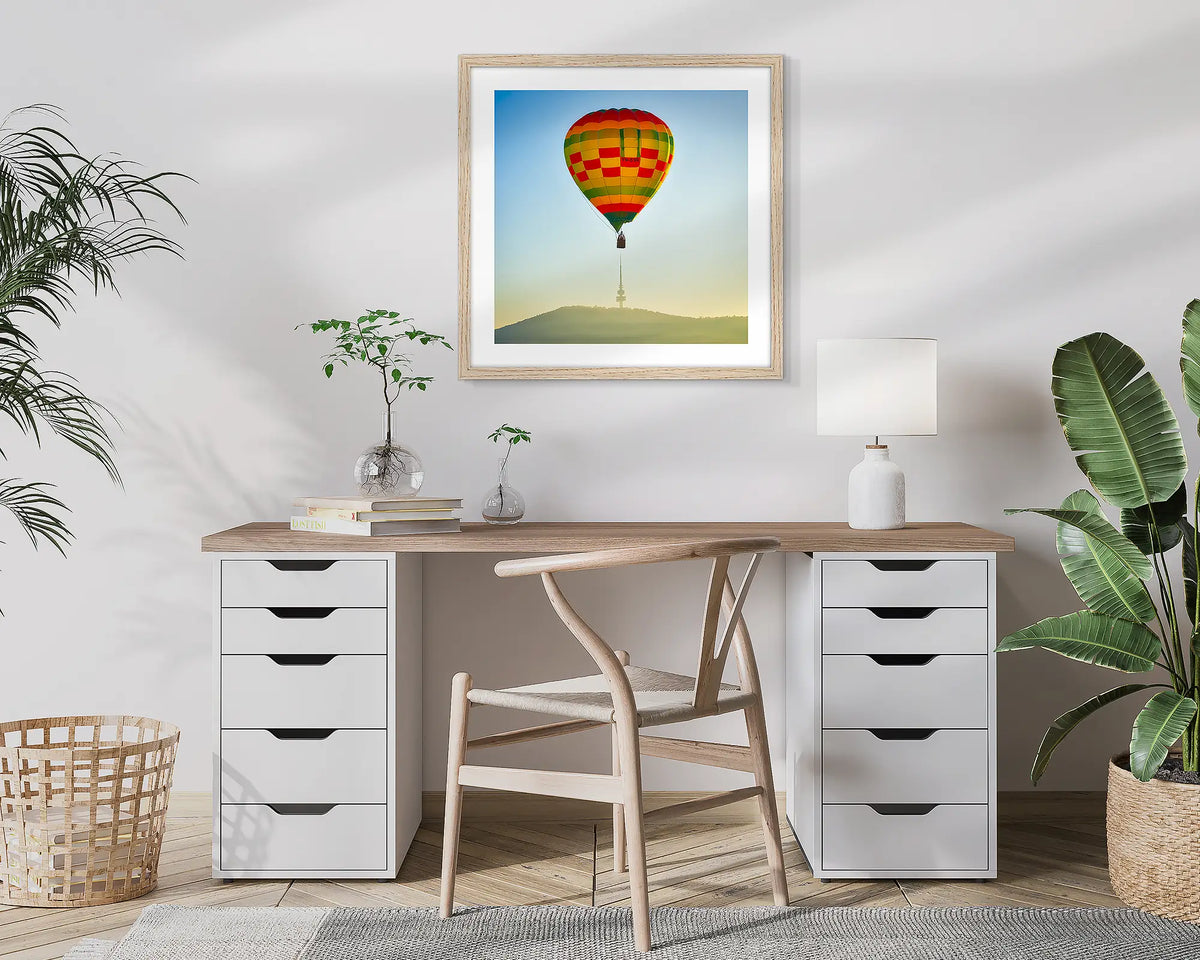 On Top. Canberra wall art print of a hot air balloon and Black Mountain Tower, framed in a timber frame and hung in a study. 