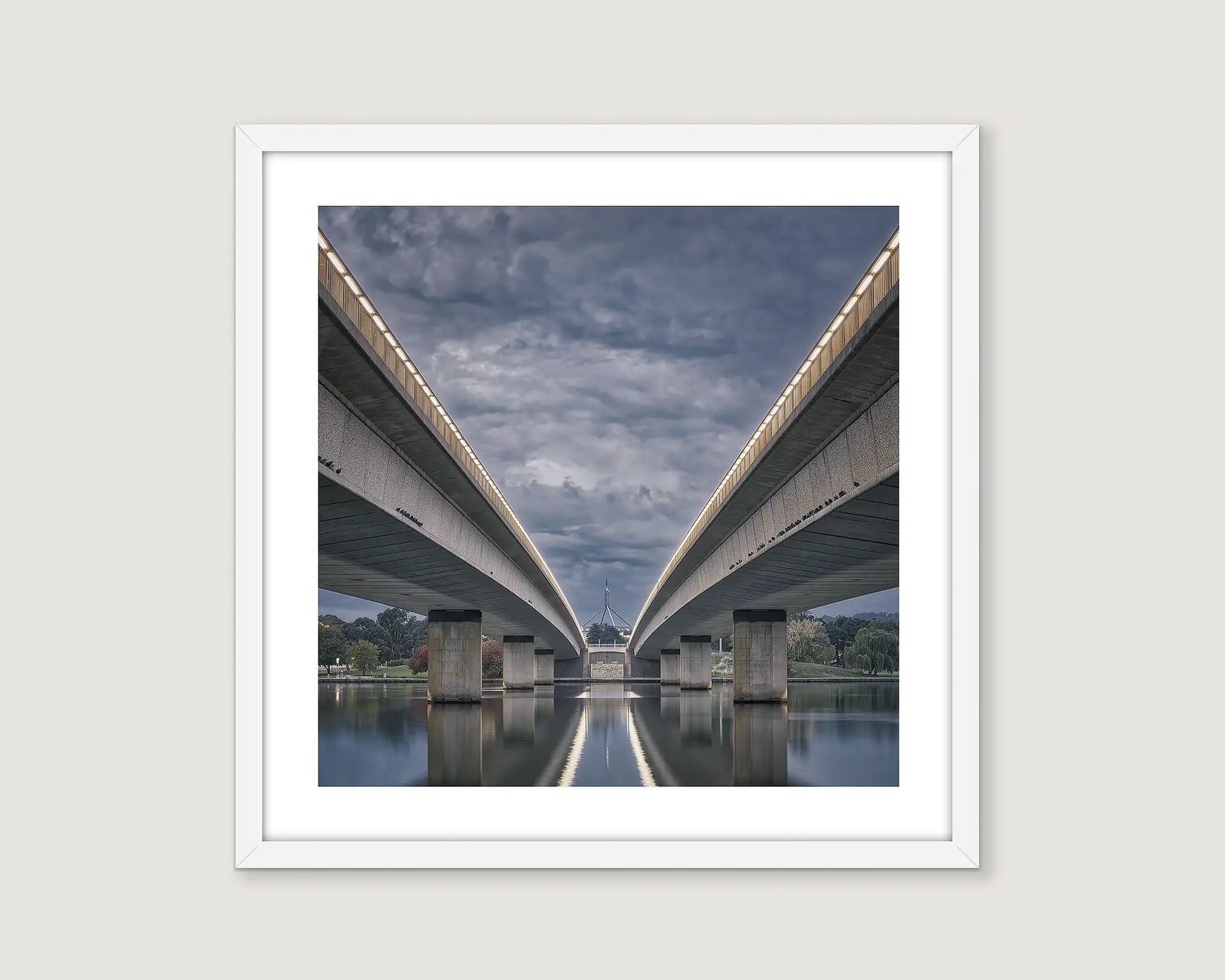 Framed photograph of bridges over a lake with a cloudy evening sky.