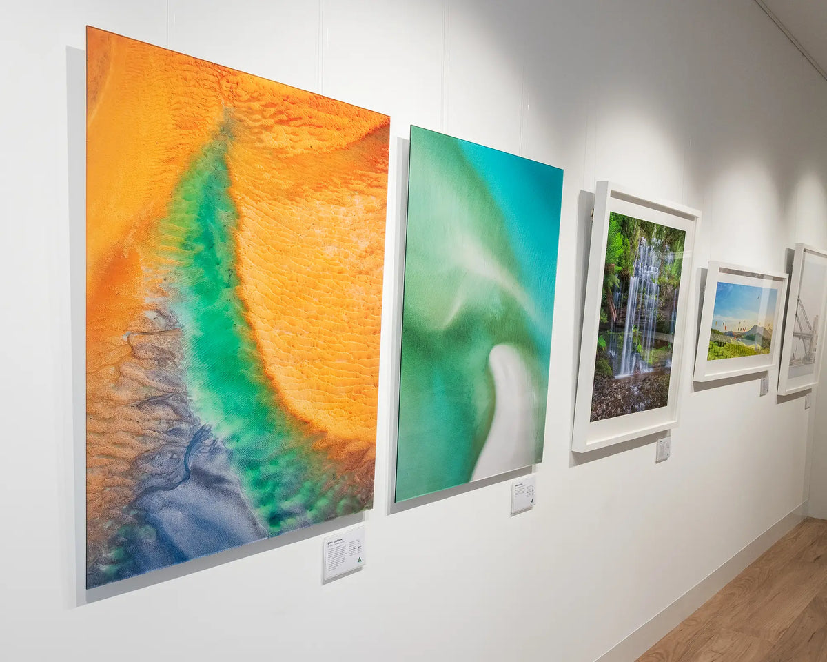 Opal Illusion. Aerial abstract coastal artwork frameless acrylic hanging in gallery.
