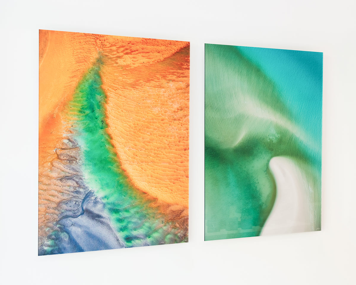 Opal Illusion. Aerial abstract coastal artwork frameless acrylic, on display in gallery with another coastal artwork.