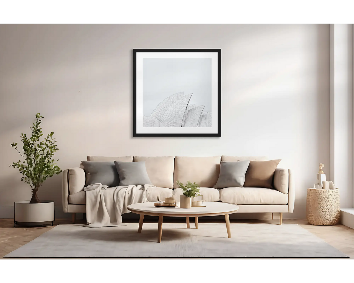 Opera House Curves. Large wall art print featuring sails of the Sydney Opera House, with a black frame, hung above a couch. 