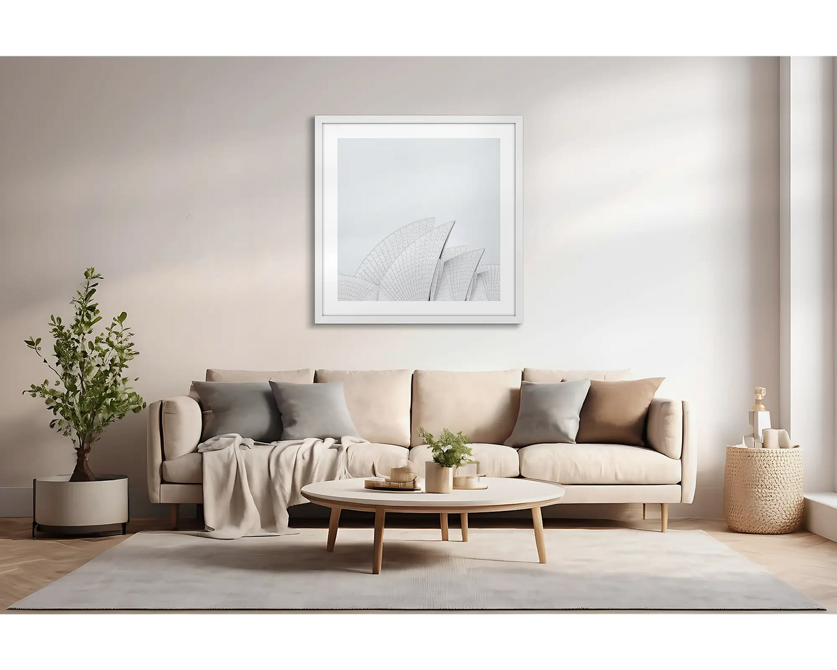 Opera House Curves. Large wall art print featuring sails of the Sydney Opera House, with a white frame, hung above a couch. 