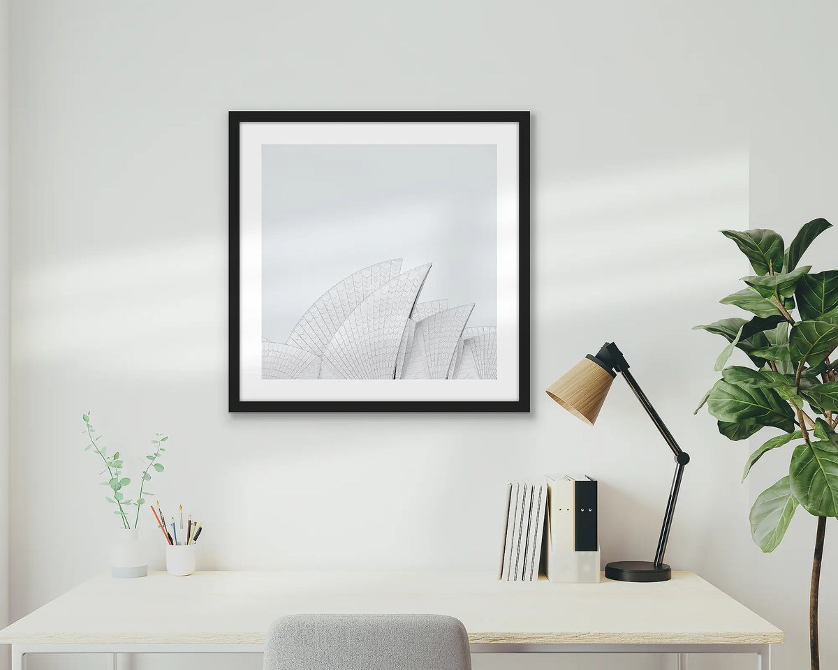 Opera House Curves. Wall art print featuring sails of the Sydney Opera House, with a black frame, hung above a home office desk.