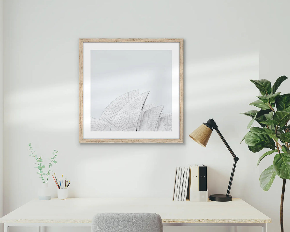 Opera House Curves. Wall art print featuring sails of the Sydney Opera House, with a timber frame, hung above a home office desk.