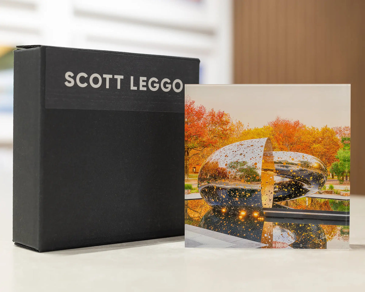 Orange Cocoon. Acrylic block of Ouroboros sculpture National Gallery of Australia Canberra, on desk with gift box.