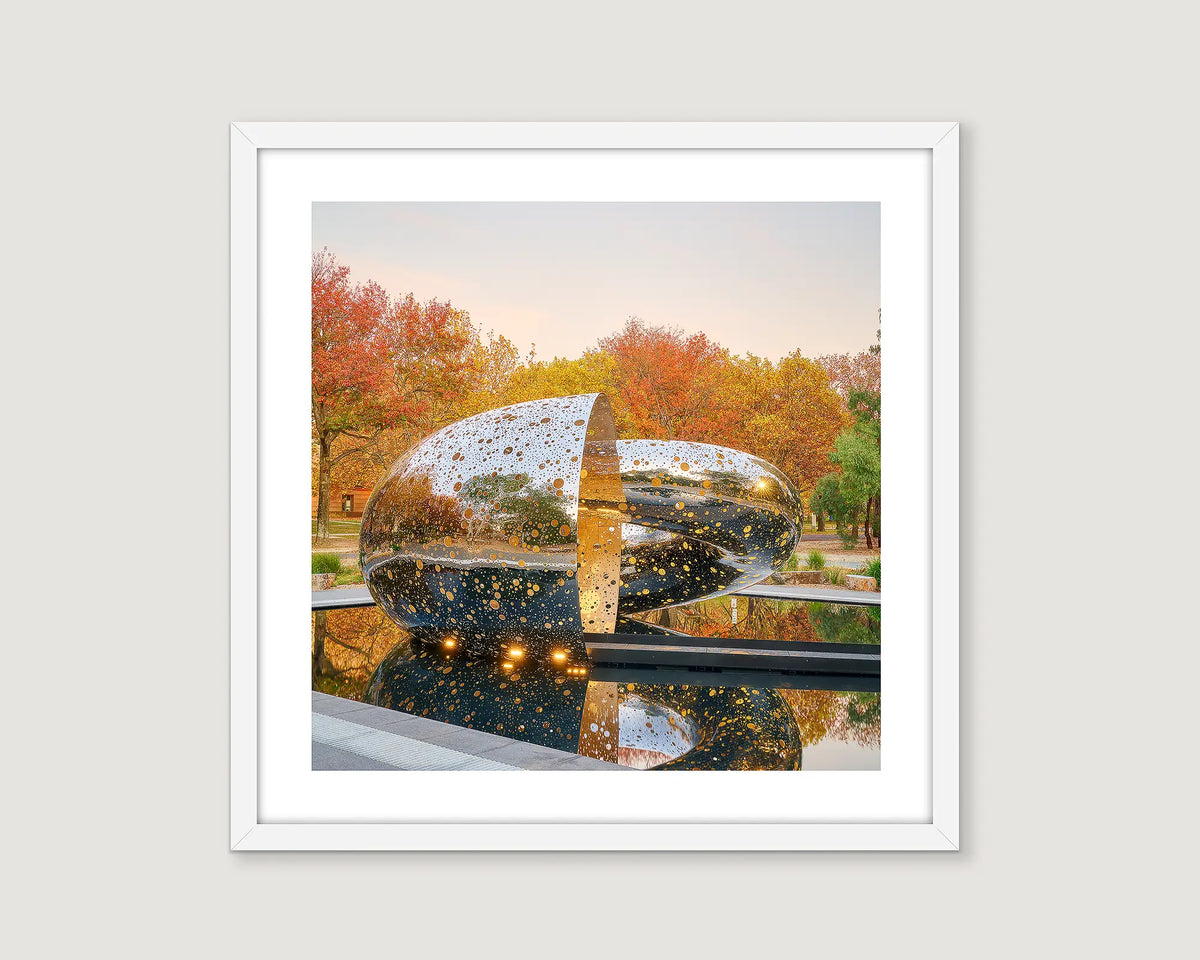 Framed photograph of an outdoor statue and orange trees.