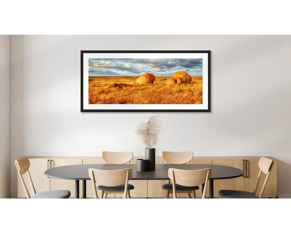 Outcrop. Photographic wall art print of Devils Marbles, Northern Territory, with a black frame, hung on a dining room wall. 