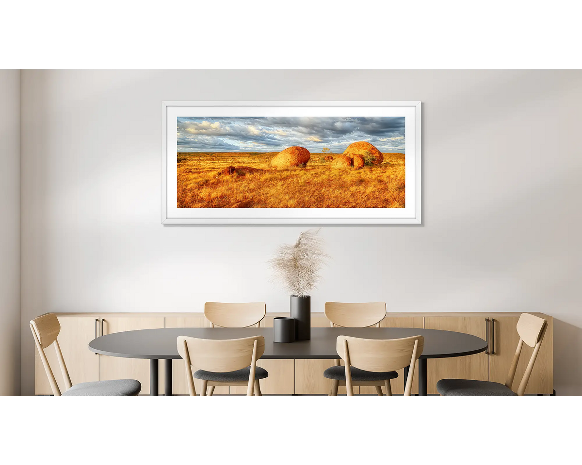 Outcrop. Photographic wall art print of Devils Marbles, Northern Territory, with a white frame, hung on a dining room wall. 