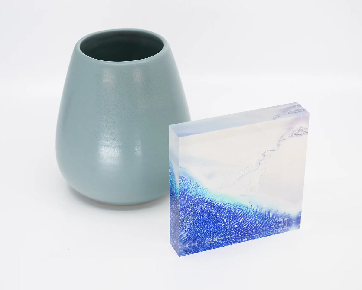 Outlet. Acrylic block of Roebuck Bay Western Australia, on desk styled with a small vase.