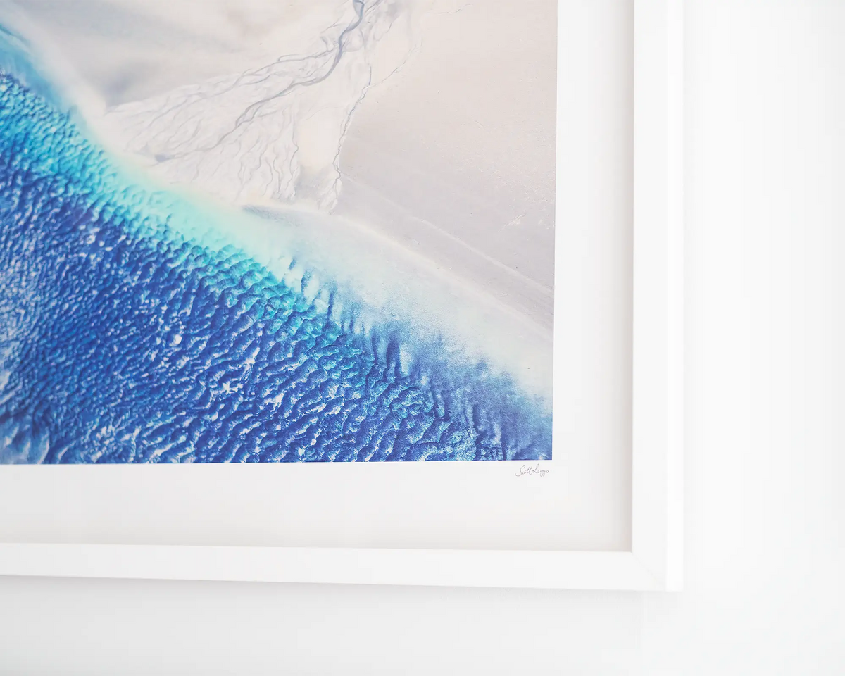 Outlet - aerial landscape photography print, framed in white frame, hanging on gallery wall.