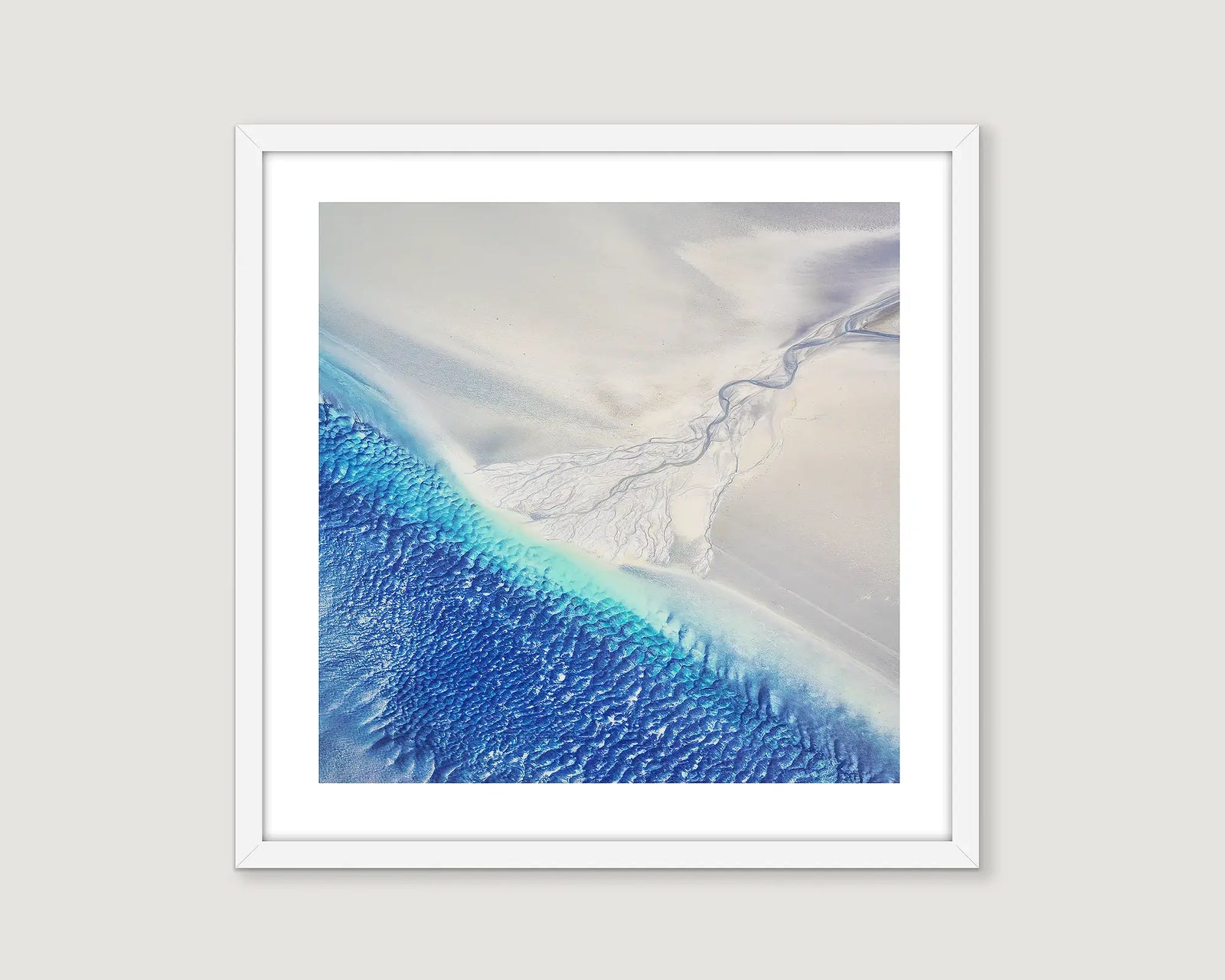 Framed abstract photograph of a beach with blues and white sand.