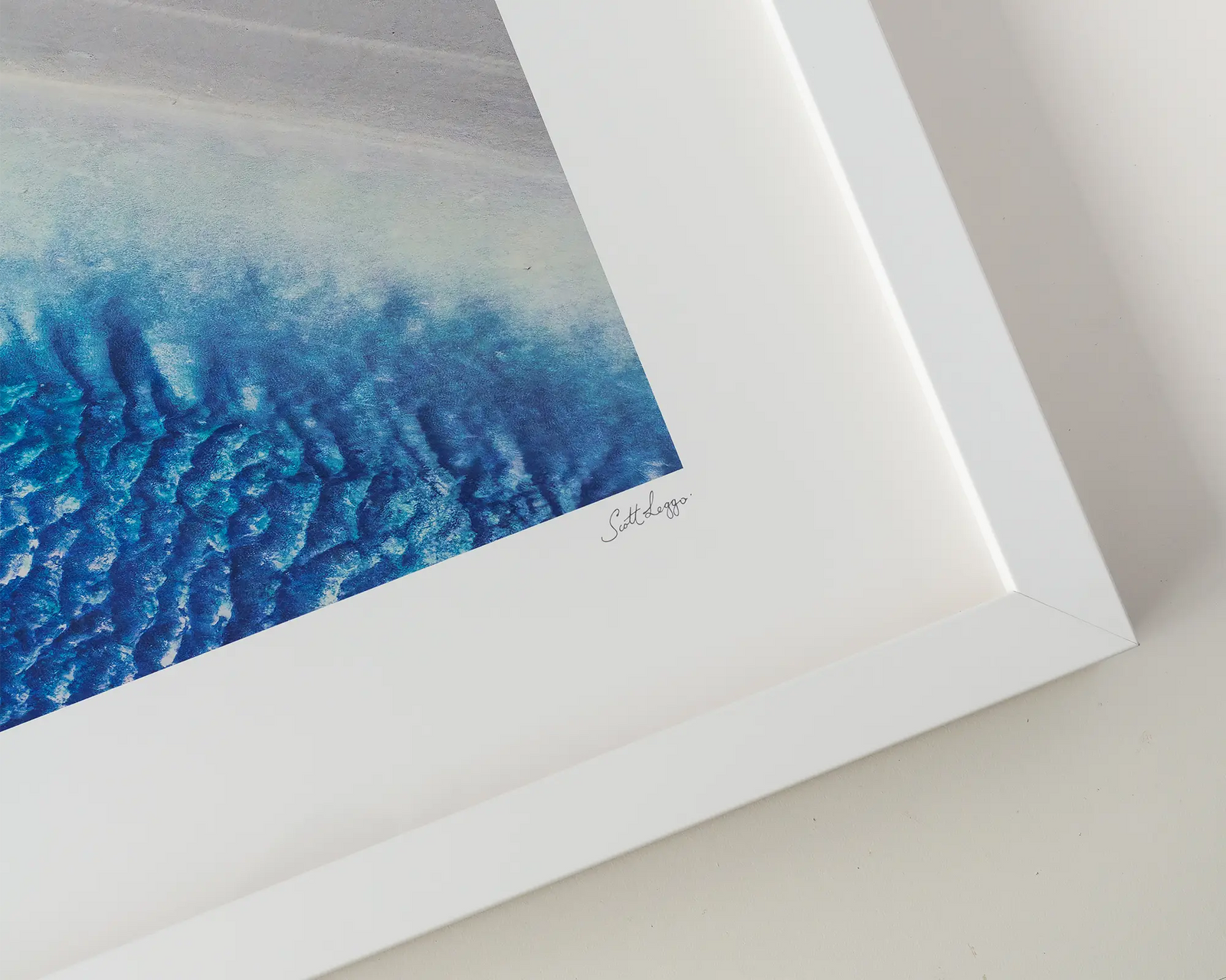 Framed abstract photograph of a beach with blues and white sand.