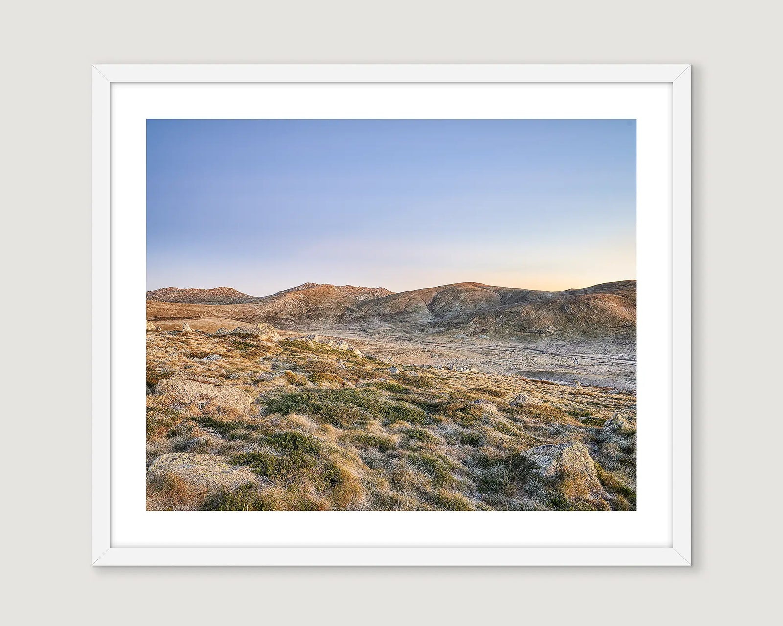 Framed landscape photograph of a mountain range with a blue sky.
