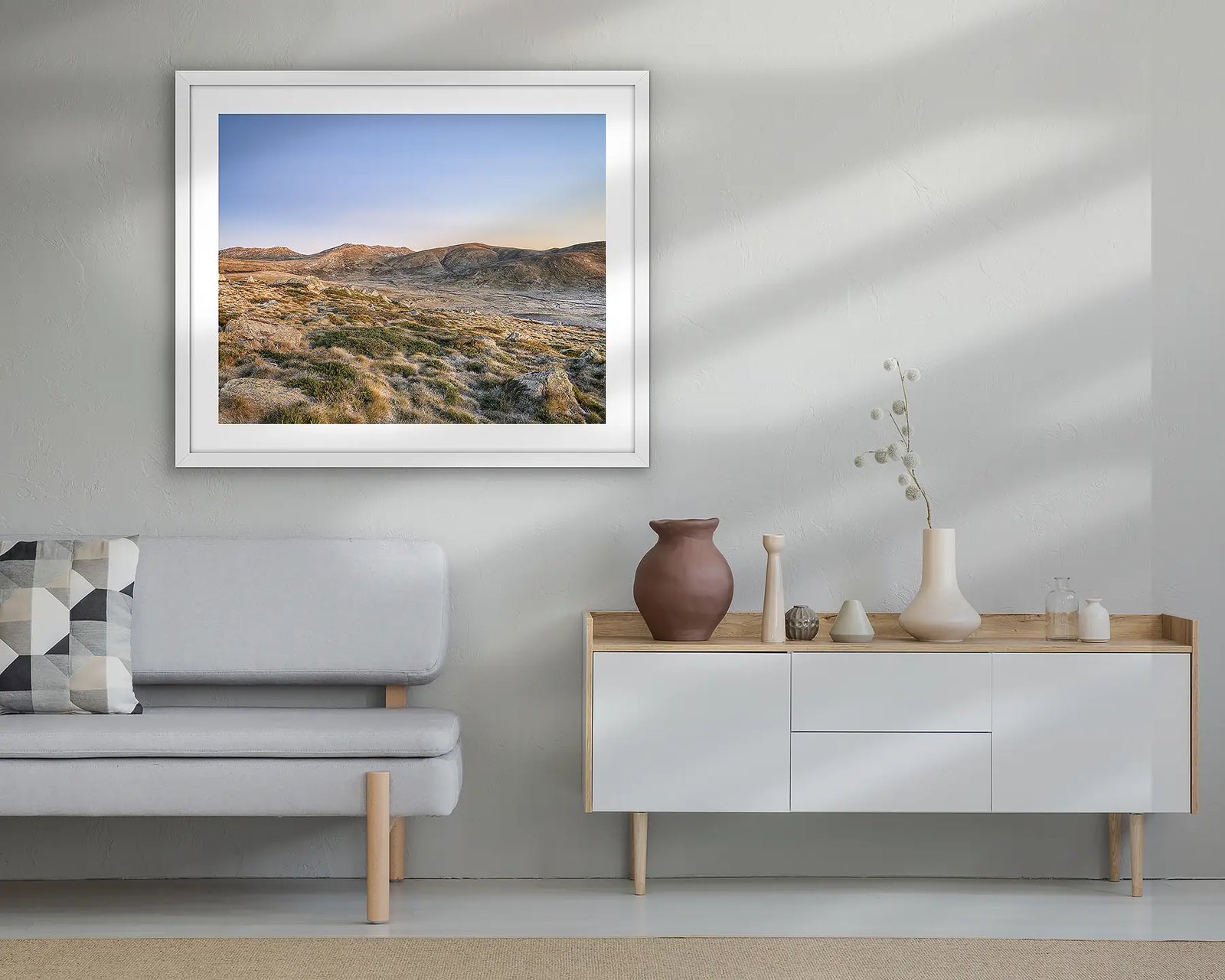 Framed landscape photograph of a mountain range with a blue sky.