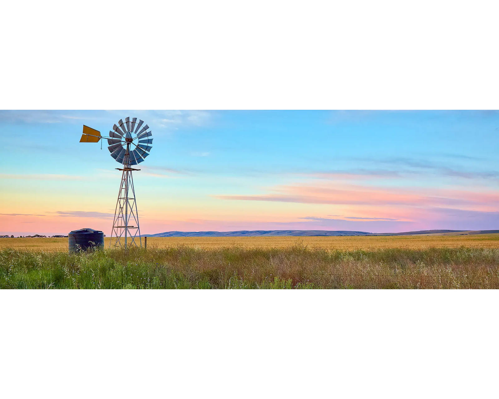 Painted Morning. Colourful sunrise with windmill on farm, South Australia.