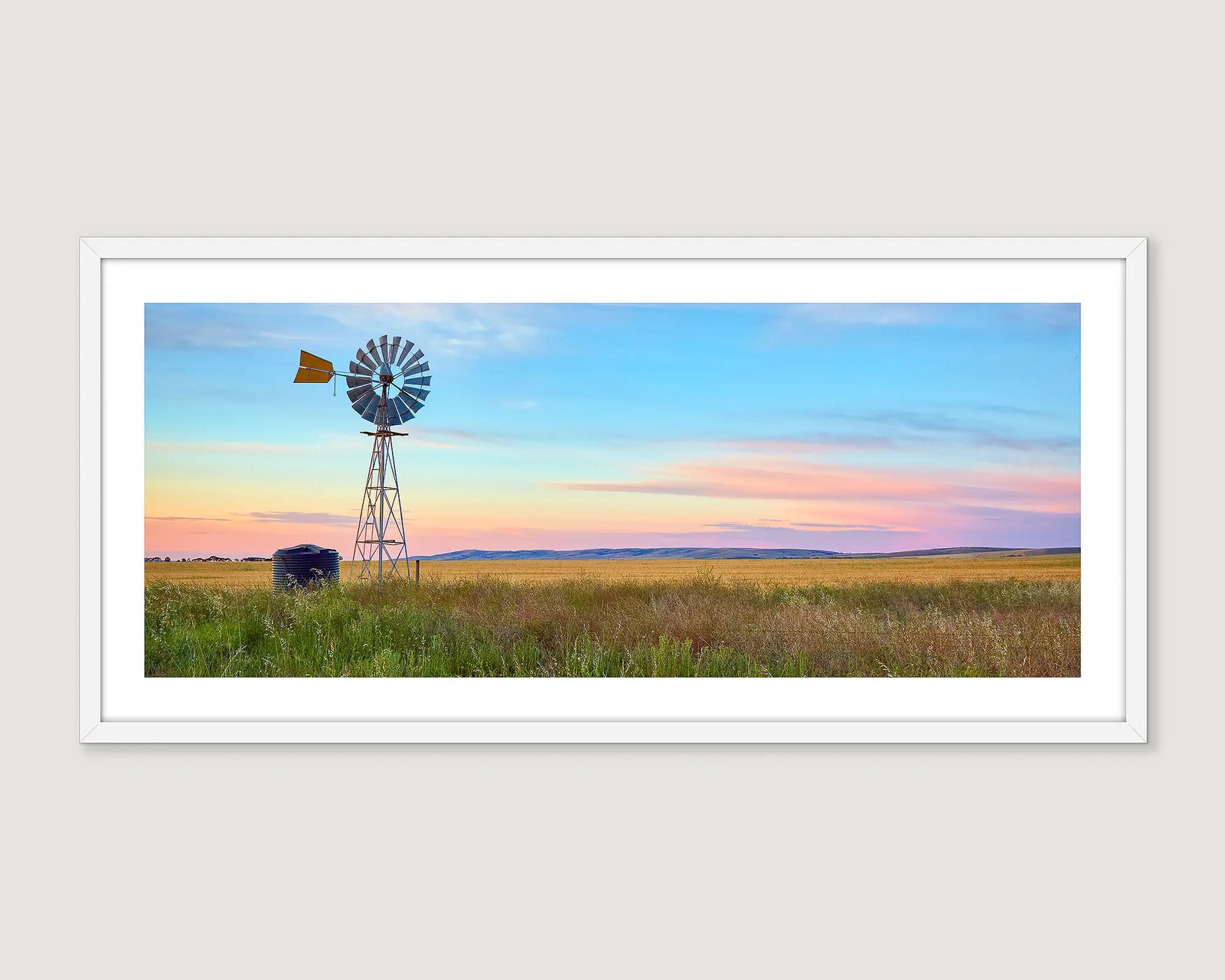 Framed photograph of a windmill in a field with a colourful sunrise.