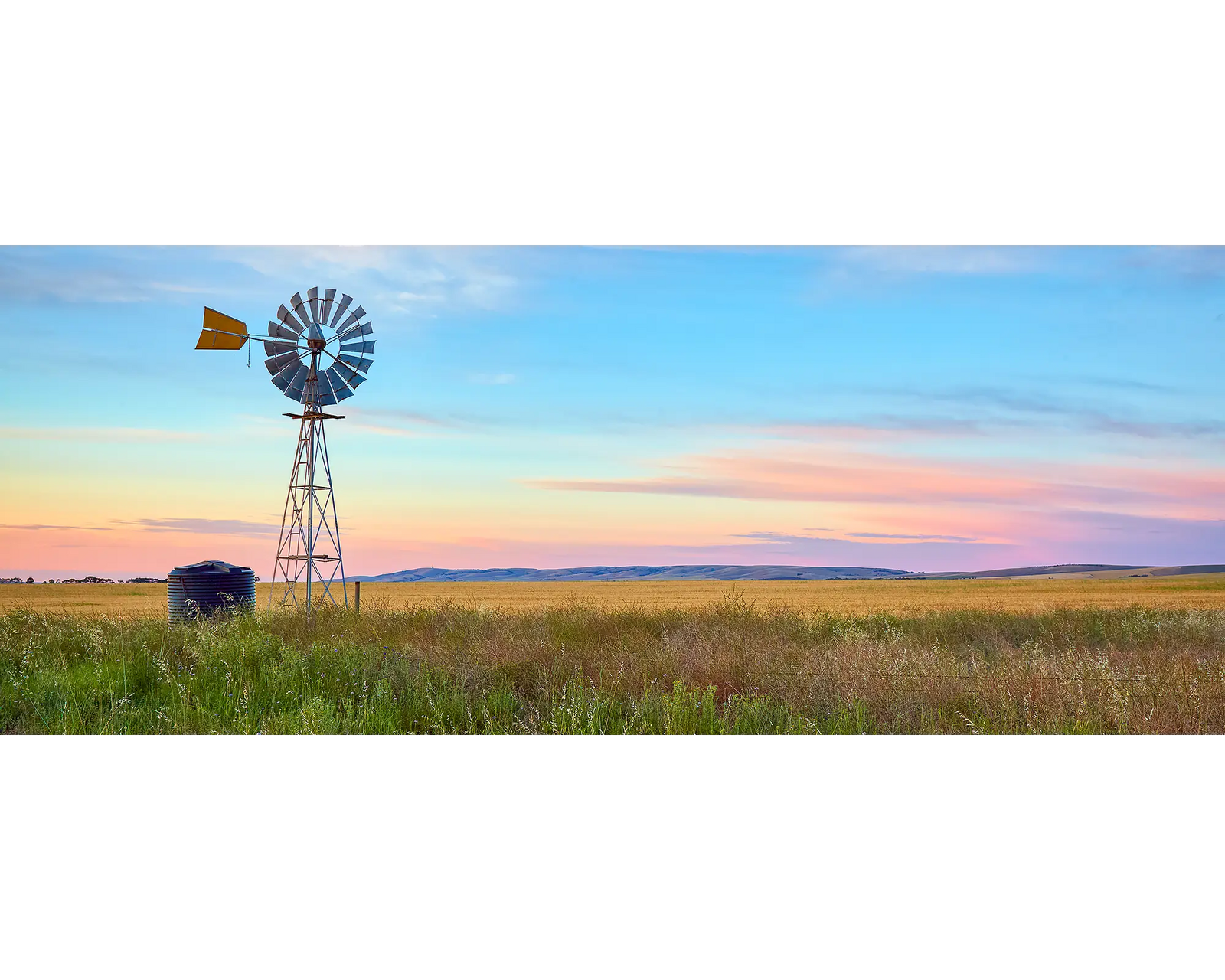 Painted Morning. Windmill on farm with colourful sunrise, South Australia.