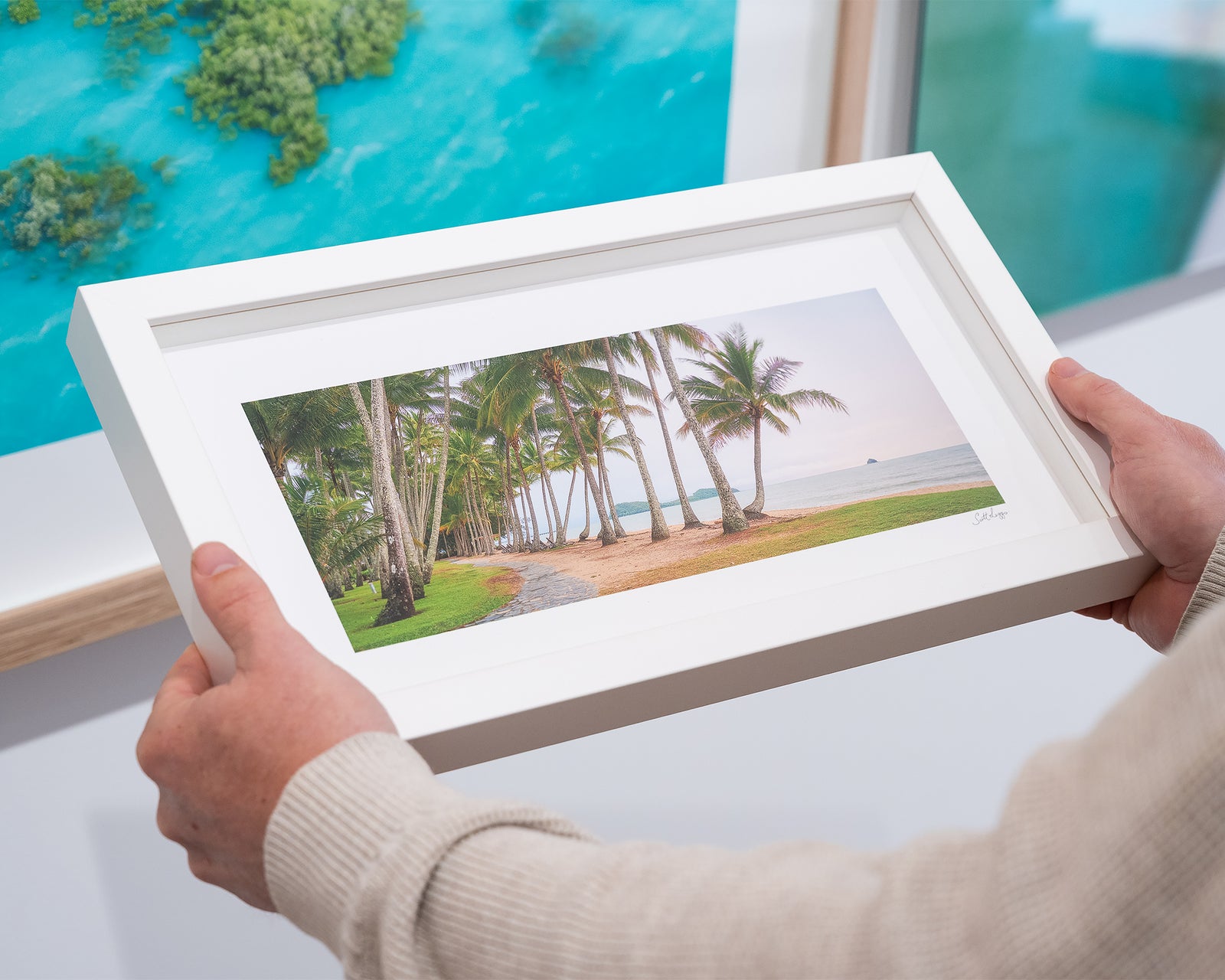 Framed photograph of palm trees and the ocean.