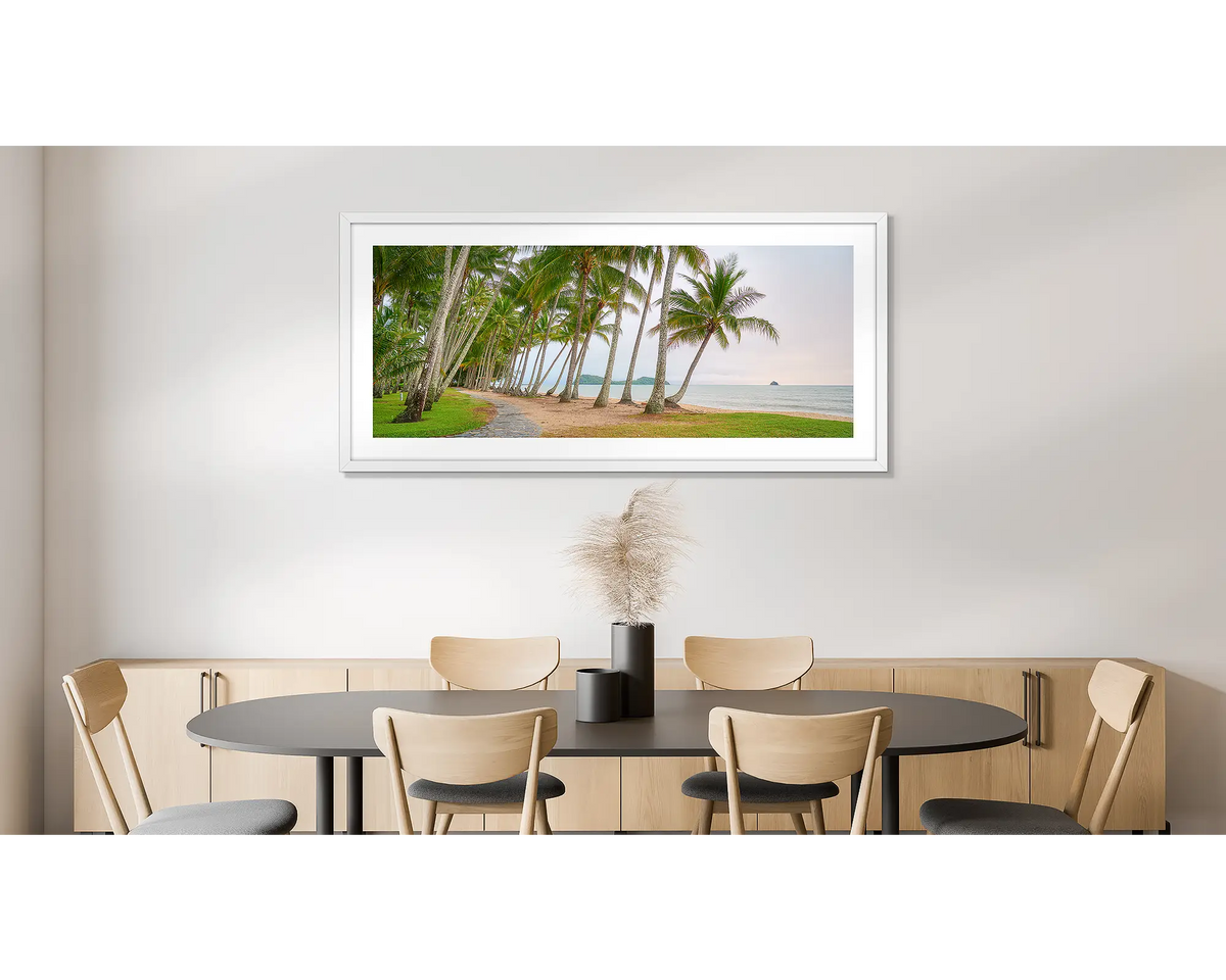 Palm Tree Tunnel. Photographic wall art print of Palm Cove, Queensland, with a white frame, hung on a dining room wall. 