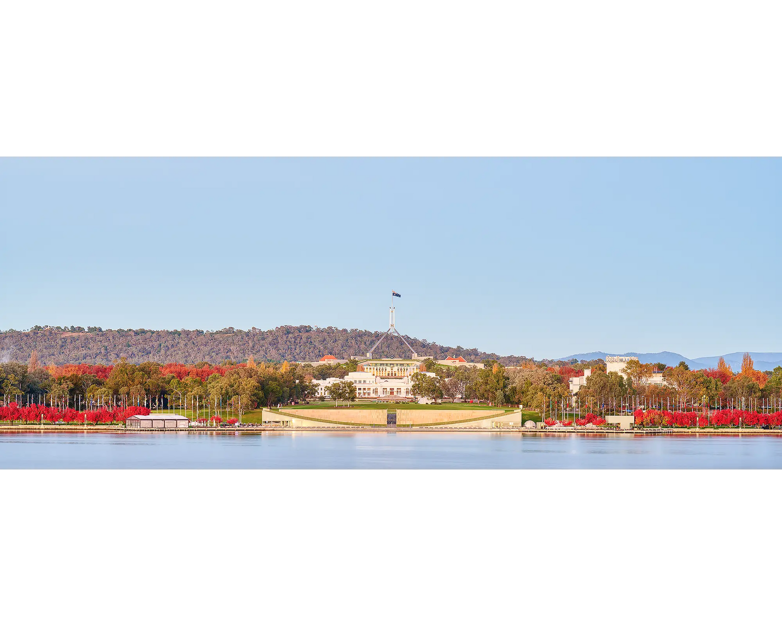 Red autumn trees use Lake Burley Griffin and in front of Old and New Parliament Houses, Canberra.
