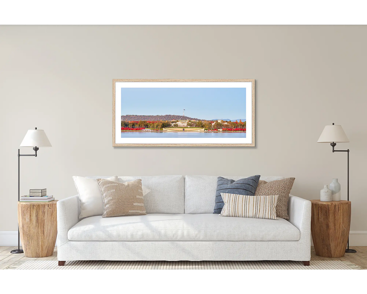 Parliamentary Reds. Wall art print of old and new Parliament House, framed in a timber frame and hung above a couch. 