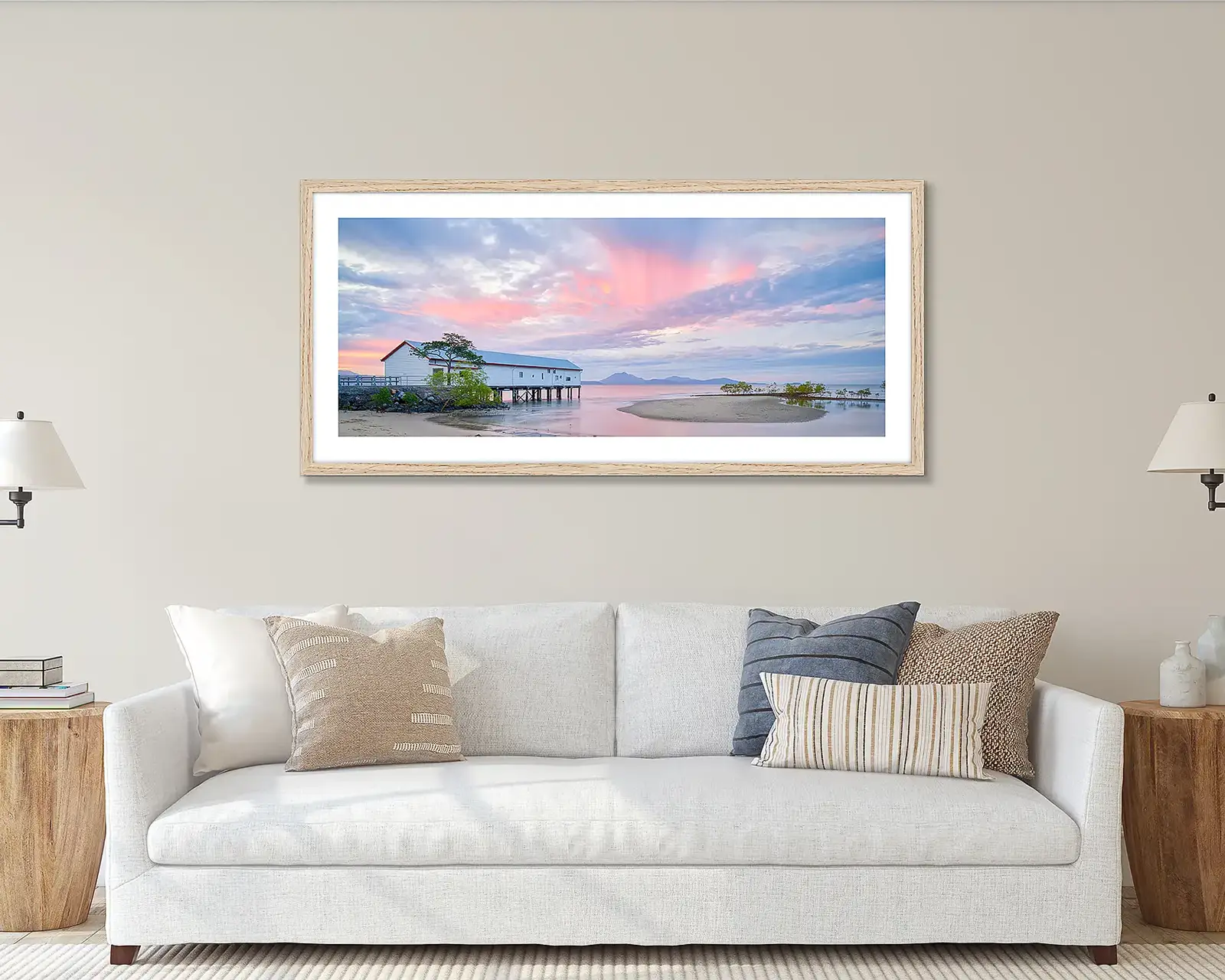 Pink wall art print of sunset hung above a couch