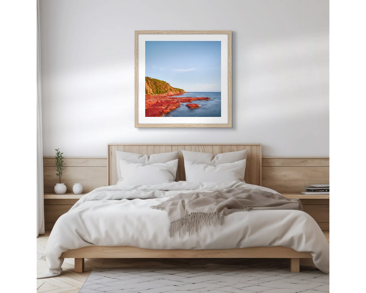 Point. Square, Merimbula wall art print with a timber frame hung above a bed. 

