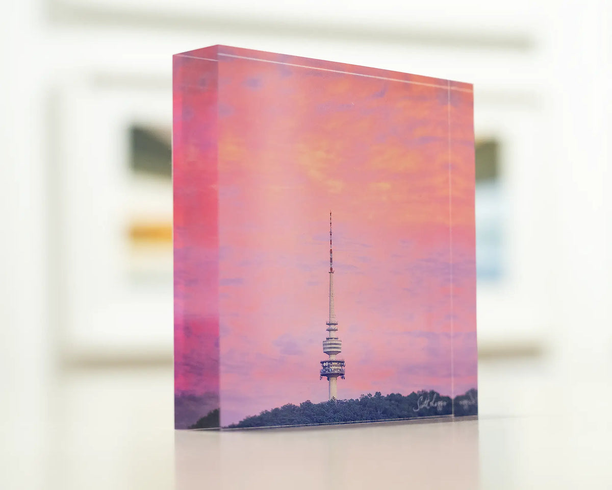 Pointer. Acrylic block of sunrise at Telstra Tower, Canberra sitting on a desk.