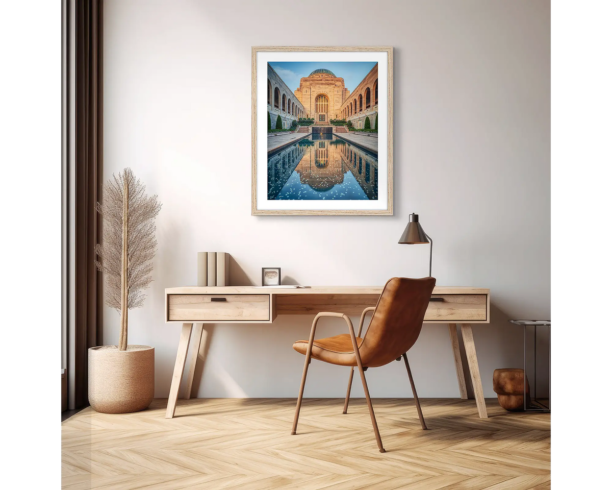 Pool of Reflection. Wall art print of the Australian War Memorial, framed with a timber frame and hung above a desk, in an apartment. 