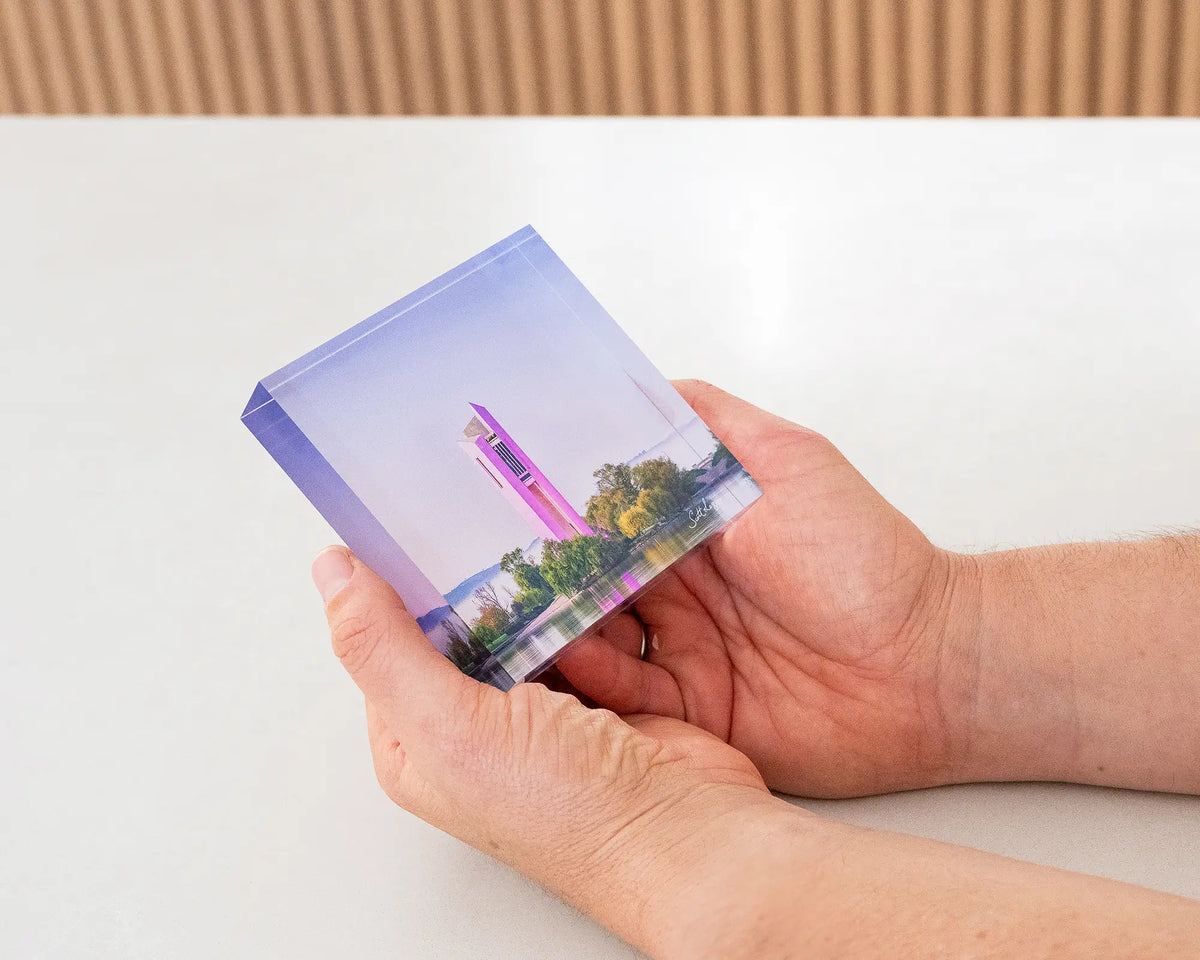 Purple Popsicle. Acrylic block of National Carillon Canberra, with purple lights, being hand held.