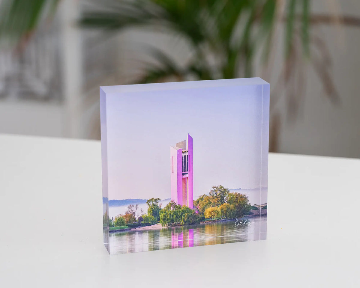 Purple Popsicle. Acrylic block of National Carillon Canberra, with purple lights, styled on a desk.