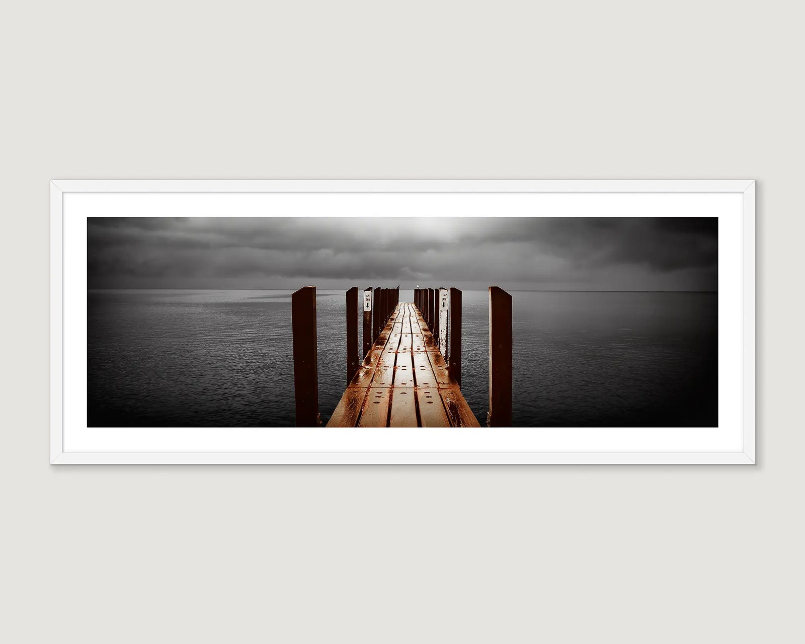 Framed photograph of a jetty leading into the ocean and a grey cloudy sky at Geographe Bay.