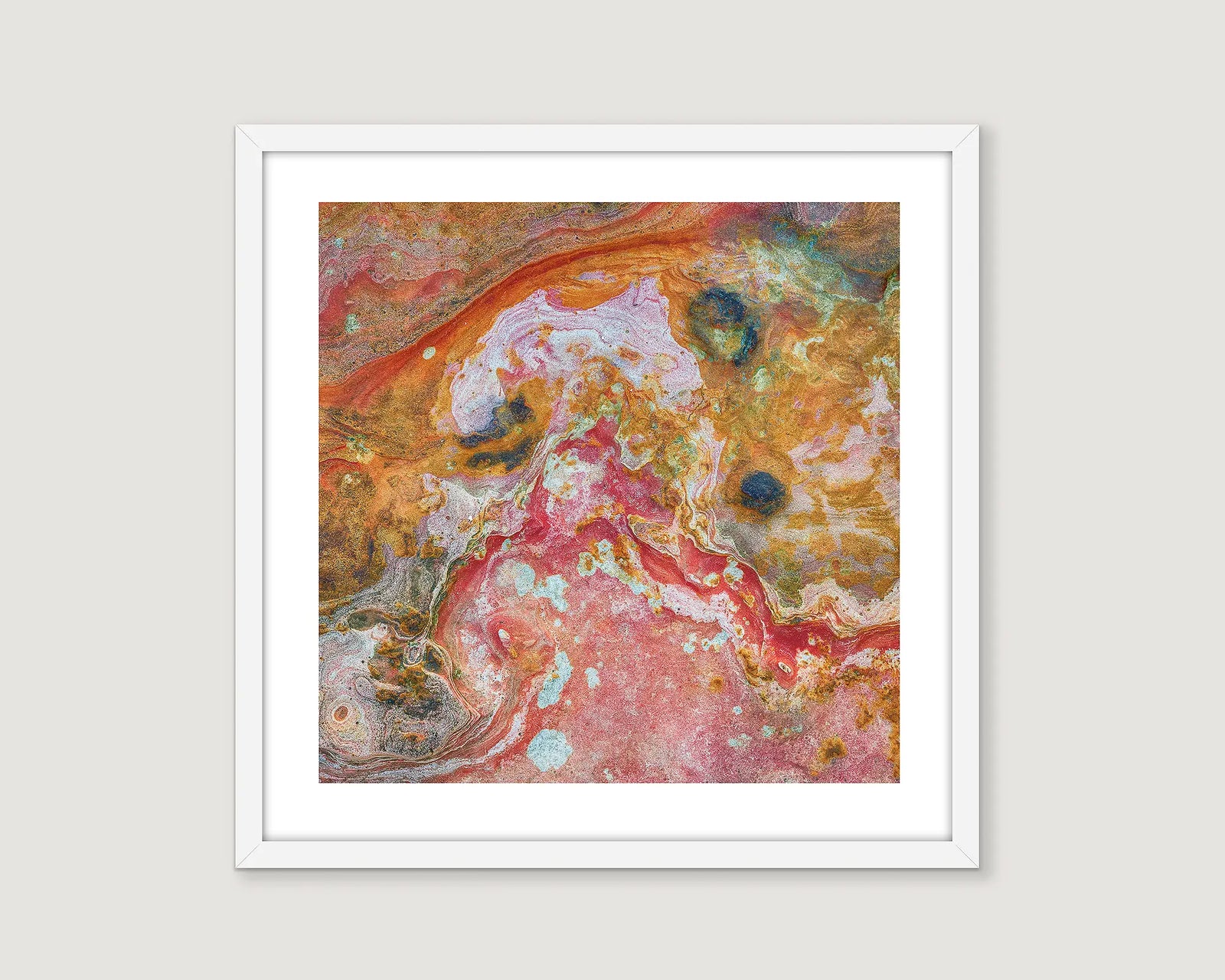 Framed abstract photograph of a rock face in shades of red, yellow, white and black.