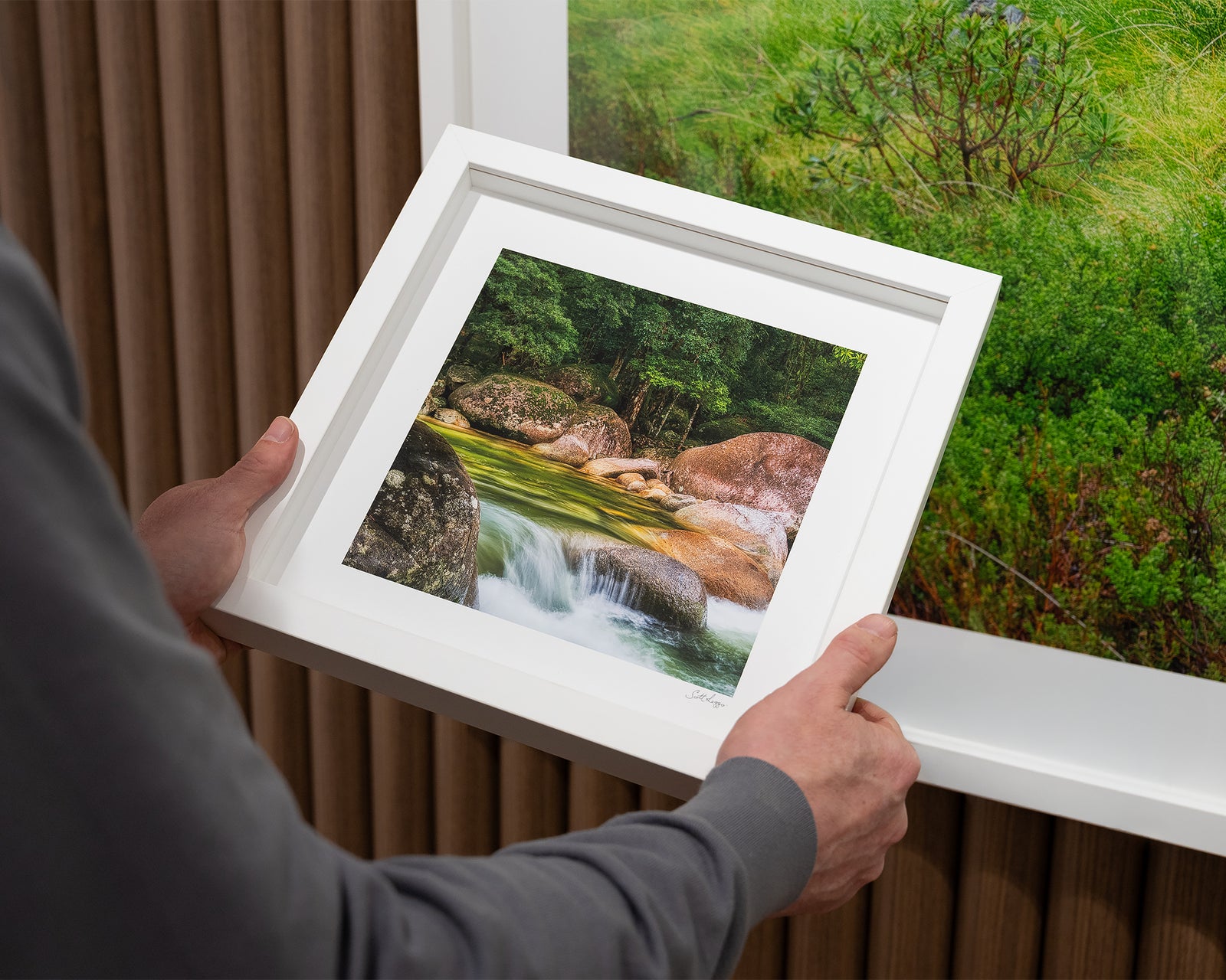 Framed photograph of a river cascading over rocks in a rainforest.