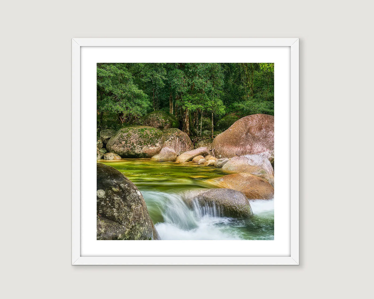 Framed photograph of a river cascading over rocks in a rainforest.