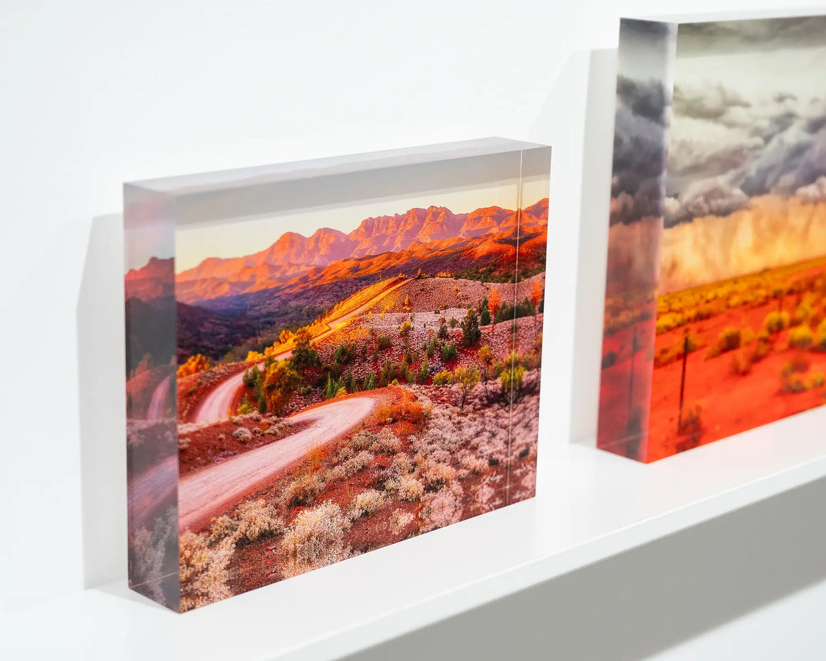 Razorback Ridge. Acrylic block of sunrise over Bunyeroo Valley and Wilpena Pound, on gallery shelf with more outback acrylic blocks.