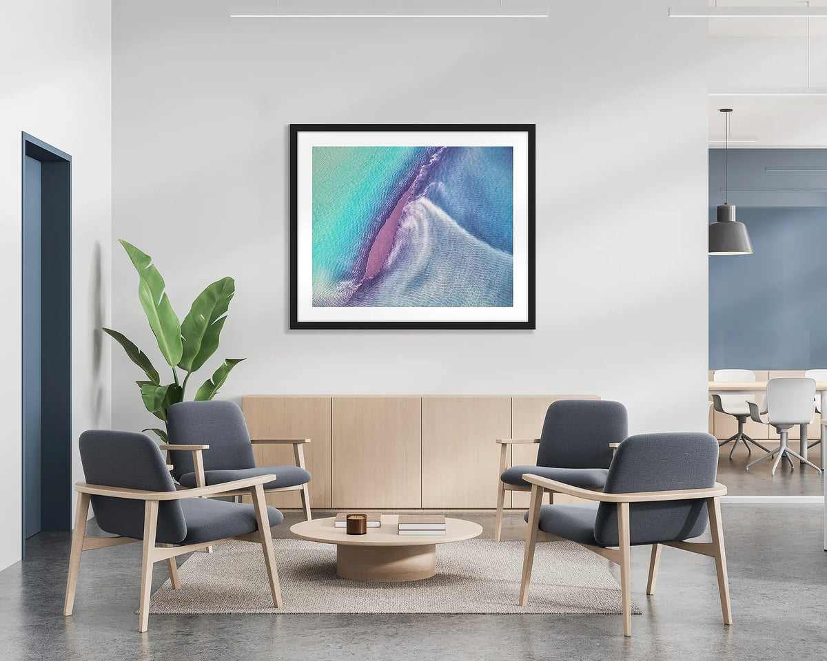 Recline.  Aerial abstract wall art print with a black frame, hung on the wall of a waiting area.