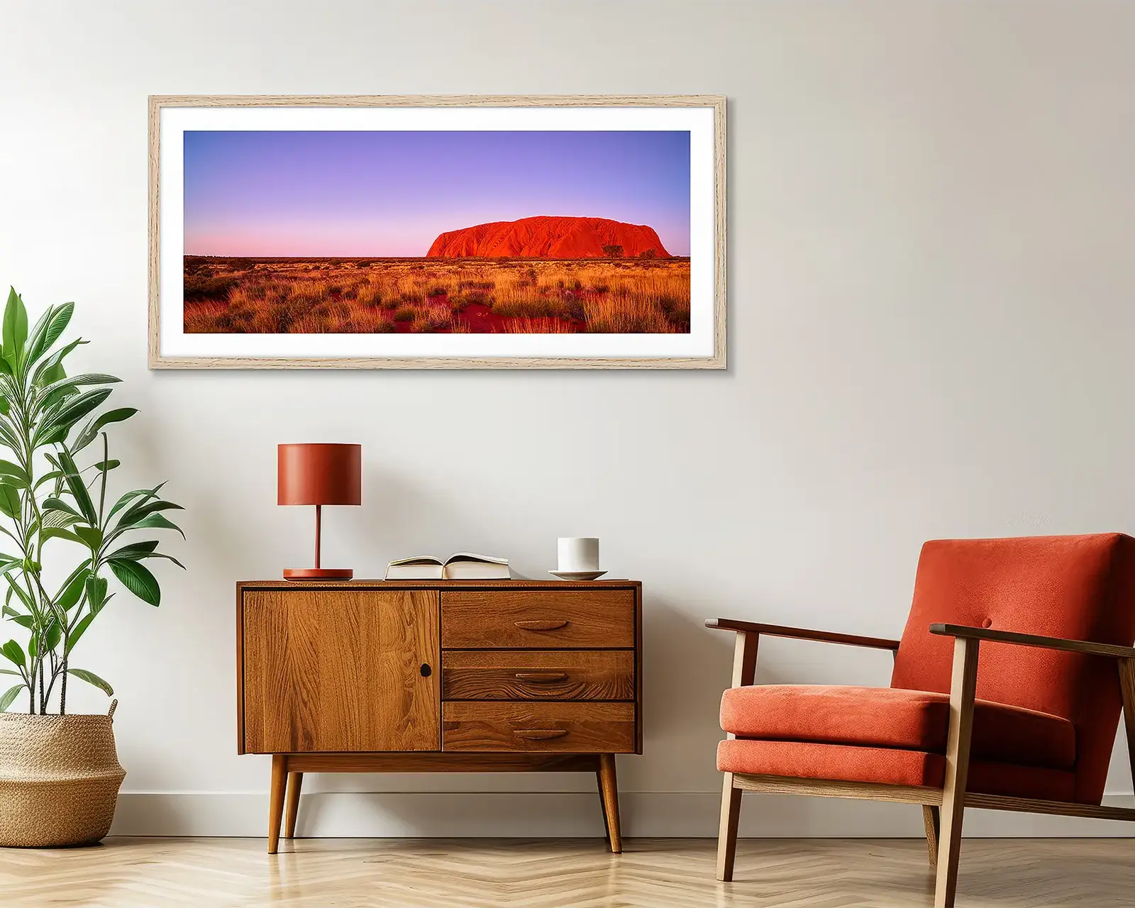 Red Uluru Outback wall art hanging on wall above side table.
