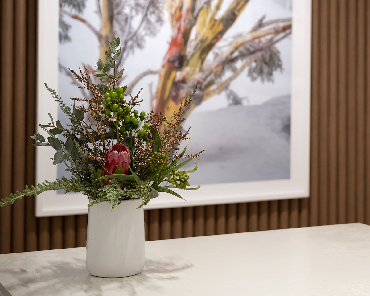 Resilience. Snow gum in snow storm Kosciuszko National Park, large wall art with flower vase in foreground.