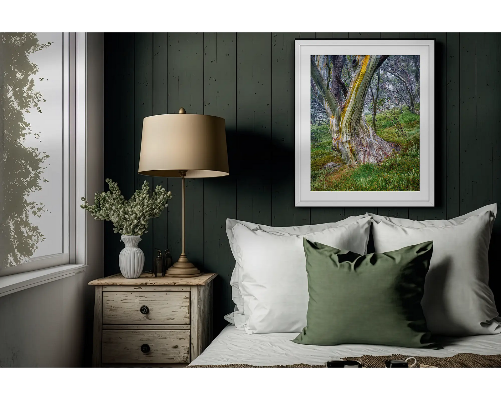 Framed landscape photograph of a snow gum with greenery and forest behind.
