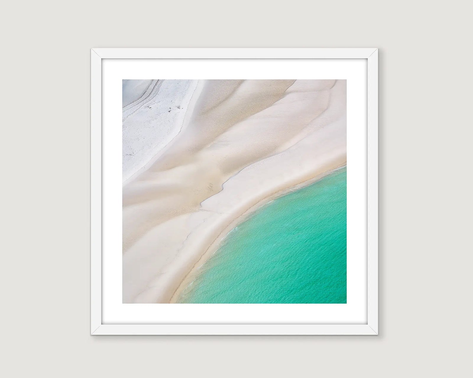 Framed abstract photograph of turquoise ocean ripples on white rippled sand.