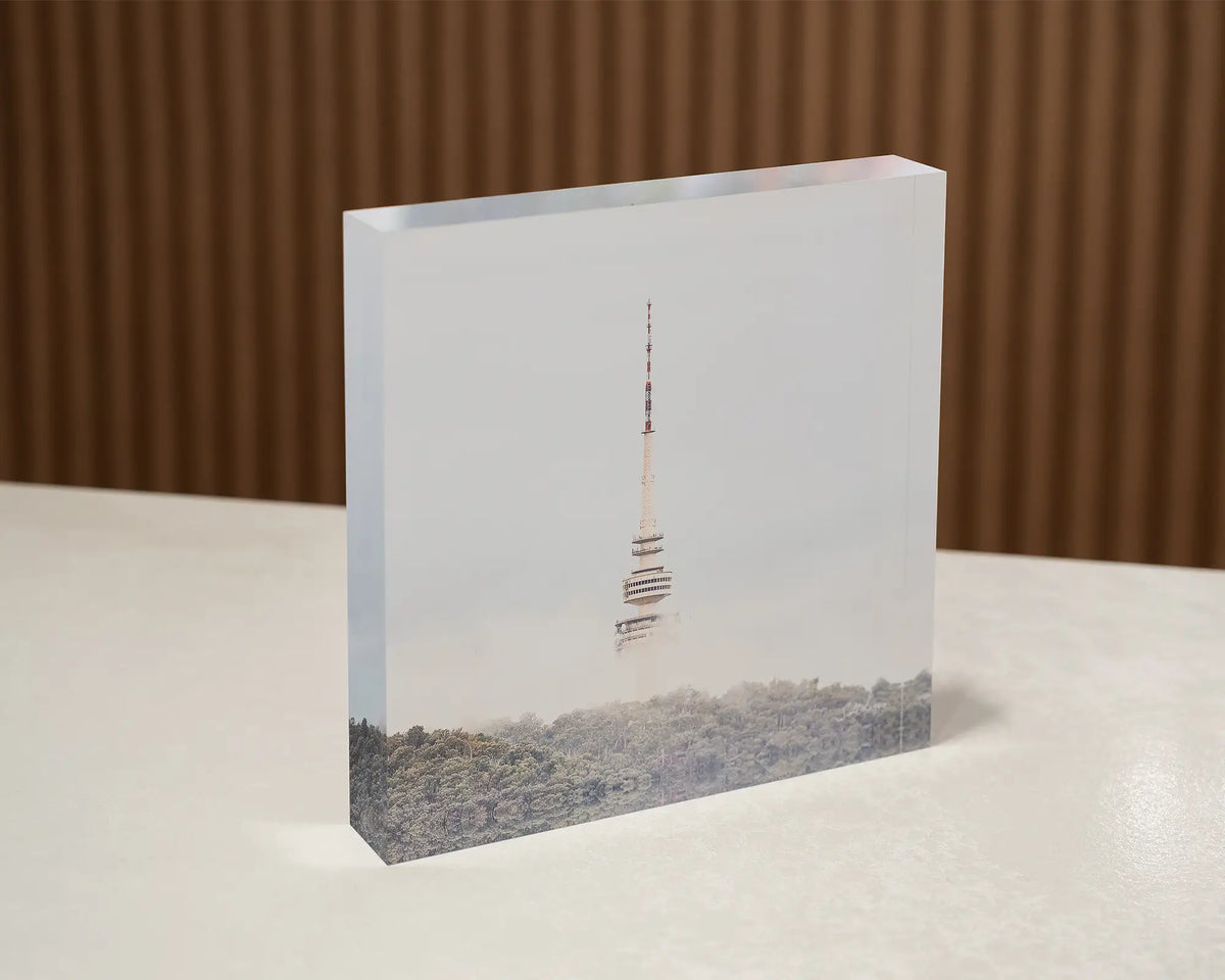 Rising. Acrylic block of Black Mountain Tower in fog, Canberra, sitting on a desk.