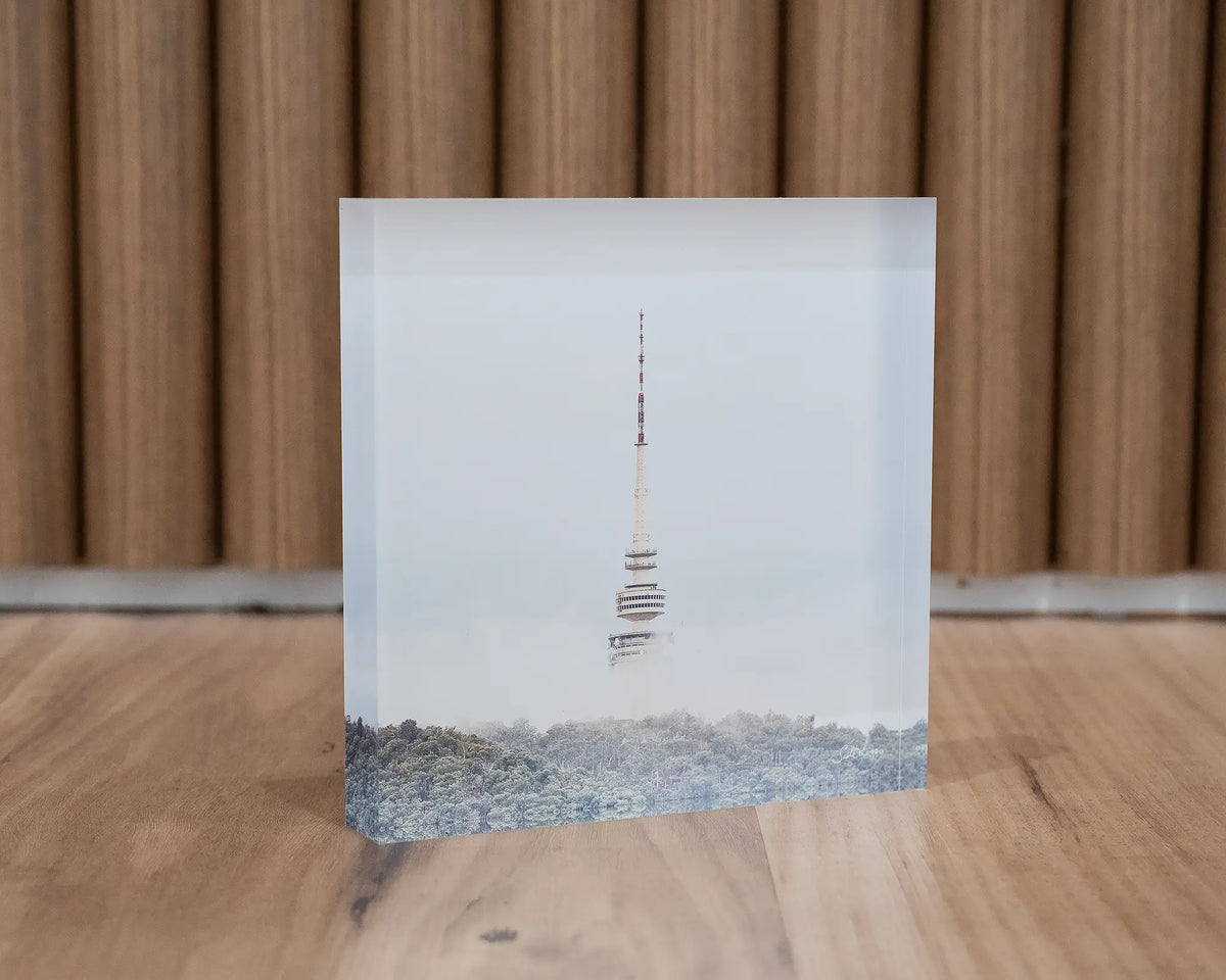 Rising. Acrylic block of Black Mountain Tower in fog, Canberra, styled with a wooden background.