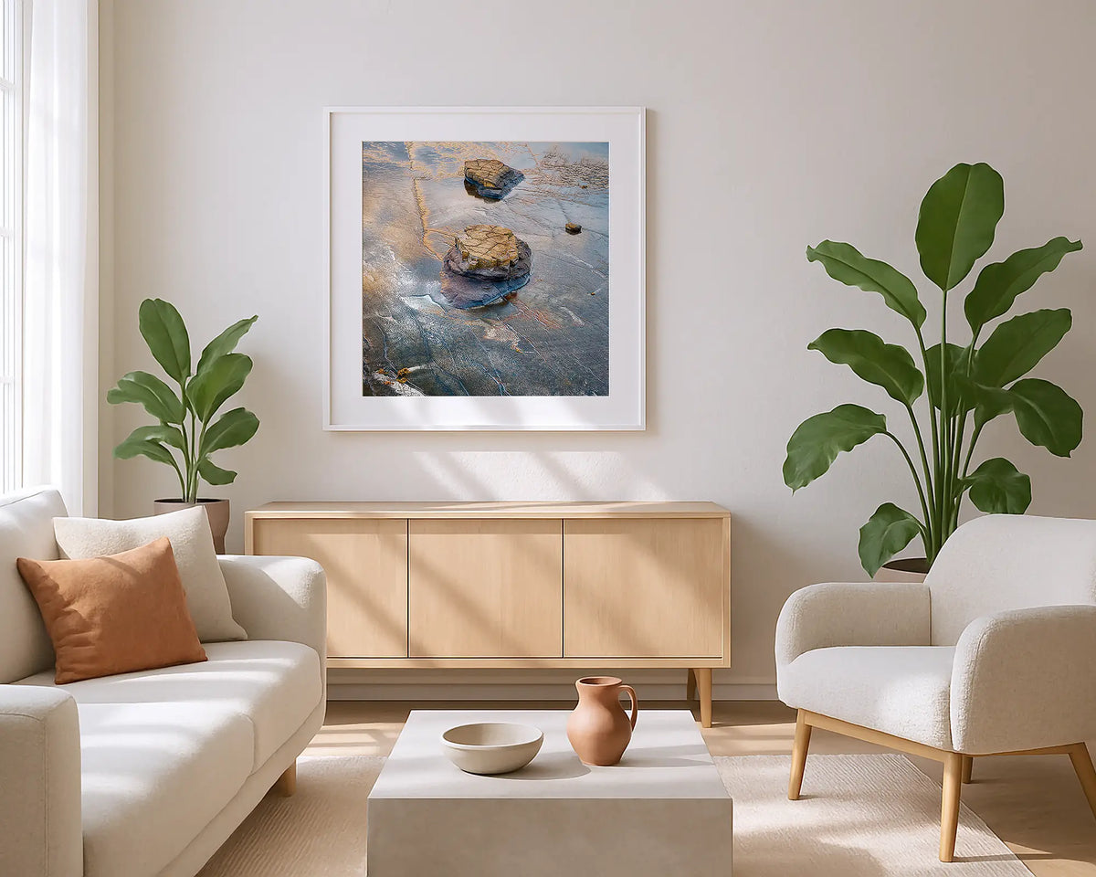 Rock on Rock.  Coastal wall art print with a white frame in a sunlit lounge.
